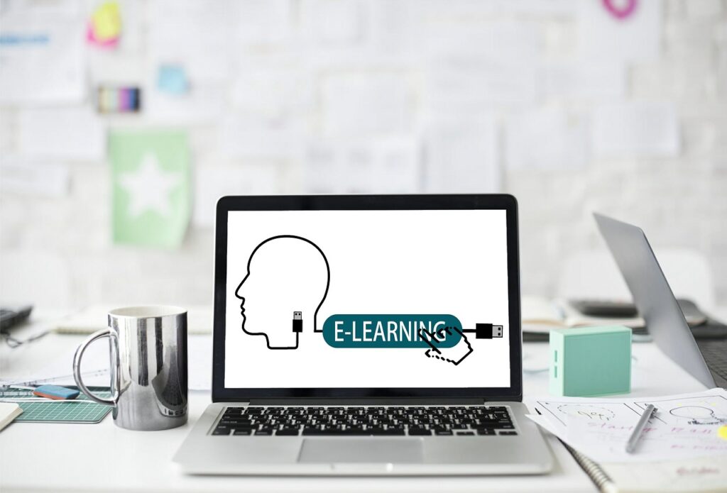 a laptop with a head made out of a cable that leads to it saying 'e-learning'.